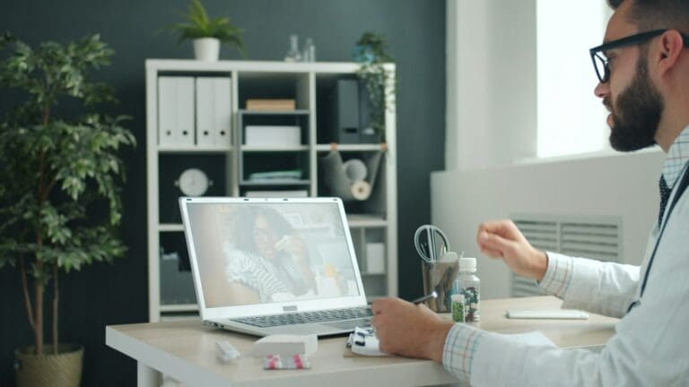 A clinician talking with a patient on a laptop video consult